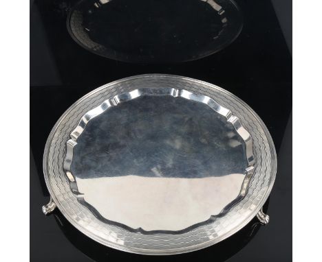 An Art Deco George V circular silver salver, engine turned decoration standing on three feet, by Cooper Brothers & Sons Ltd, 