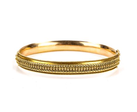 A late 20th century 9ct gold Etruscan style hinged bangle, cannetille and rope twist decoration, import hallmarks London 1986