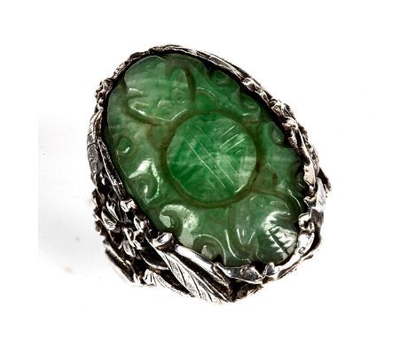 A Chinese Arts and Crafts sterling silver jade panel ring, bat and roundel design with pierced reticulated floral shoulders a