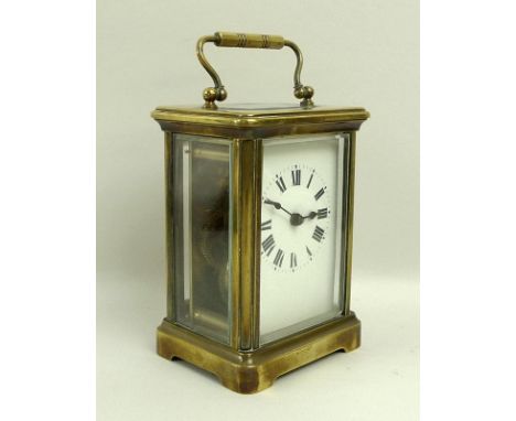 A French brass carriage clock, early 20th century, white dial with black Roman numerals, 8 by 6.5 by 10cm, with key and red c