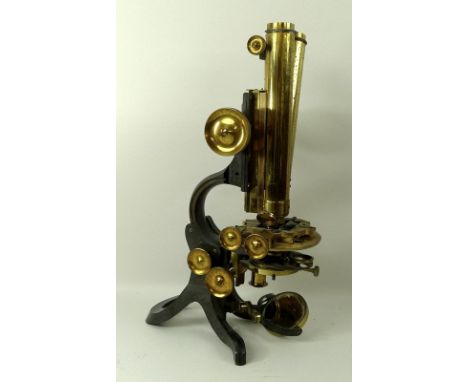 A brass and black enamelled binocular compound microscope, by Swift & Son, London, with a lacquered finish on a horseshoe sta