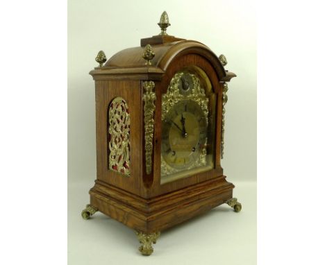 An oak cased mantel clock, 19th century, W&H and Sons, of architectural form, the domed top above brass dial with spandrel fr