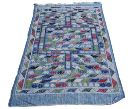 A Persian light blue ground wool work rug, woven in multicolours with animal and geometric patterns, 115 by 187cm.