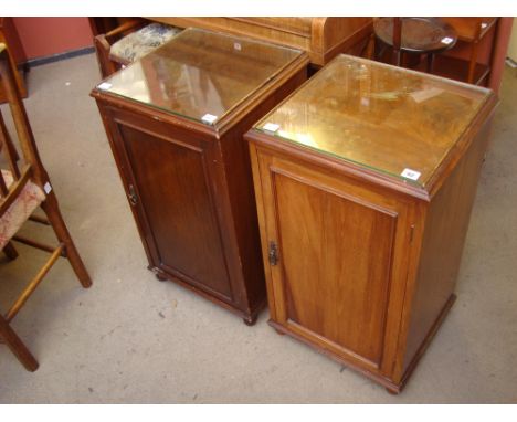 A pair of Edwardian mahogany bedside cabinets, with panelled cupboard doors with outline moulding enclosing a shelf. 