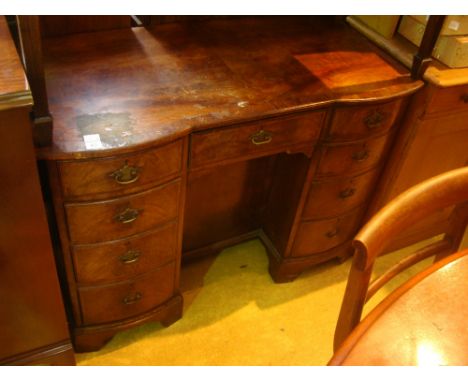 An early 20th Century, 18th Century style walnut kneehole dressing table, the crossbanded top above a central drawer and flan