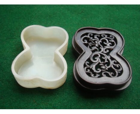 A Chinese carved white jade brush washer, of rectangular lobed form, the sides carved with scrolling flowers and foliage, on 