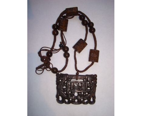 A Chinese nephrite jade lock pendant, pierced and carved with central plaque framed by dragons. 