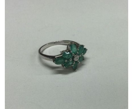 An emerald and diamond cluster ring. Approx. 3 grams. Est. £30 - £40.