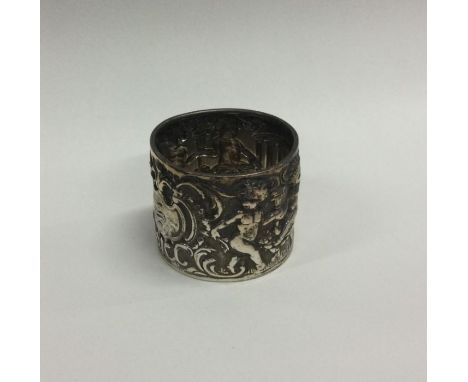 A large silver napkin ring decorated with figures. Approx. 34 grams. Est. £25 - £30.