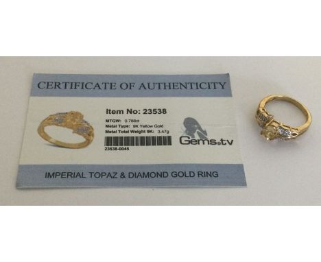 An Imperial topaz and diamond ring set in 9 carat. Approx. 3.47 grams. Est. £25 - £35.