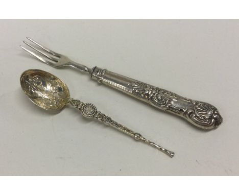A cast silver anointing spoon together with a pickle fork. Approx. 23 grams. Est. £10 - £15.