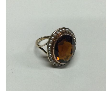 A good pearl and topaz ring in 9 carat setting. Approx. 7 grams. Est. £60 - £80.