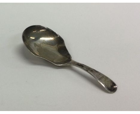 An OE pattern silver caddy spoon with crested terminal. London. Approx. 11 grams. Est. £30 - £40.