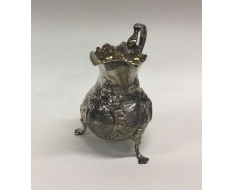 A Georgian silver helmet shaped cream jug decorated with swans and figures. London. Approx. 89 grams. Est. £50 - £80.