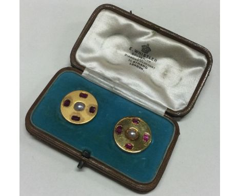 A boxed pair of fine quality ruby and pearl cufflinks with central pearls set in high carat gold. Approx. 15 grams. Est. £400