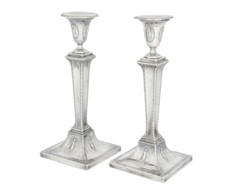 A pair of late Victorian silver candlesticks, Sheffield, 1889, Hawksworth, Eyre & Co., the spreading square bases decorated w