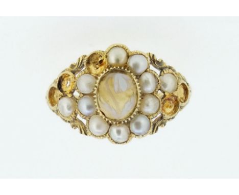 An early 19th century gold ring set floral carved hardstone within pearl surround,(five pearls deficient), size M, inscribed 