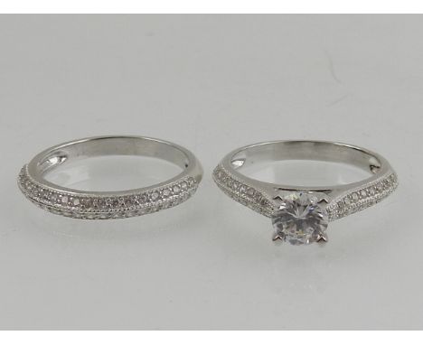 A silver and cubic zirconia ring, together with a matching half eternity ring. (2)