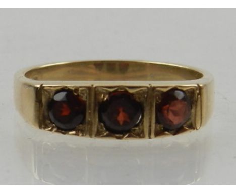 A 9 carat yellow gold and three stone garnet ring. 