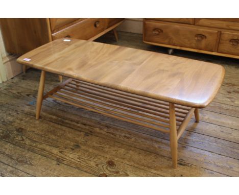 A blonde Ercol beech and elm coffee table on tapered legs with stretcher under tier