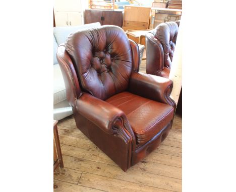 A red leather button back armchair by Saxon