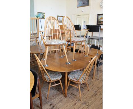 An Ercol blonde beech and elm drop leaf dining table and six chairs including two carvers