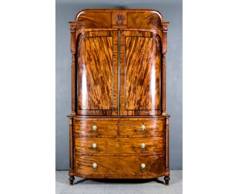 A George IV Gentleman&rsquo;s Figured Mahogany Bow and Breakfront Wardrobe, the upper part with shaped and carved cornice, fi