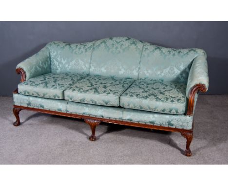 A Victorian Camel Back Three Seat Settee of "Georgian" Design, with scroll carved arm terminals, the back, seat and arms upho