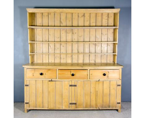 An Early 19th Century Pine Dresser, the upper part with moulded cornice, fitted three open shelves, the base fitted three fri