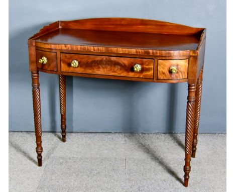 A George IV Figured Mahogany Side Table, with shaped tray top, fitted one real and two dummy drawers, on spiral turned suppor