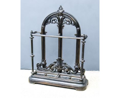 A Victorian Black Painted Cast Iron Umbrella/Stick Stand, with arched and moulded back, with scroll supports, two division tr