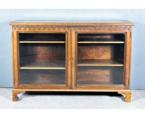 A Mahogany Dwarf Bookcase, with moulded edge to top, fitted four shelves enclosed by a pair of glazed doors, with shaped moul