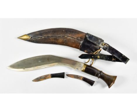 A Gurkha Kukri, 11ins broad leaf pattern bright steel blade, stamped 69, hardwood grip with brass pommel, in leather scabbard