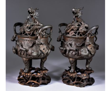 A Pair of Chinese Patinated Bronze Censers and Covers, the covers&nbsp;pierced with dragons, animals and clouds, the bulbous 
