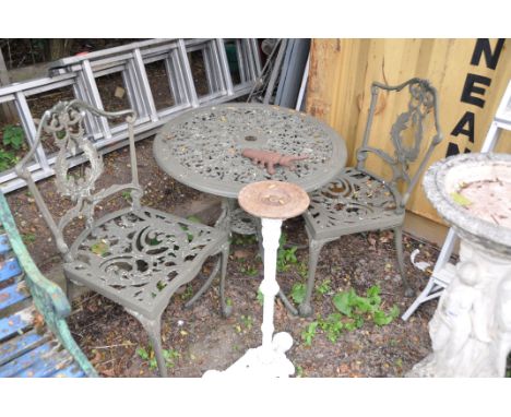 A MODERN CIRCULAR CAST ALUMINIUM GARDEN TABLE 69cm in diameter with two matching chairs, a Scarab door stop and a cast iron p