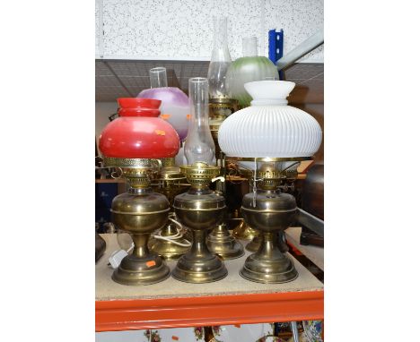 A GROUP OF EIGHT VICTORIAN OIL LAMPS, mainly brass and metal bases, assorted coloured glass shades (8 + 1 chimney) (Condition