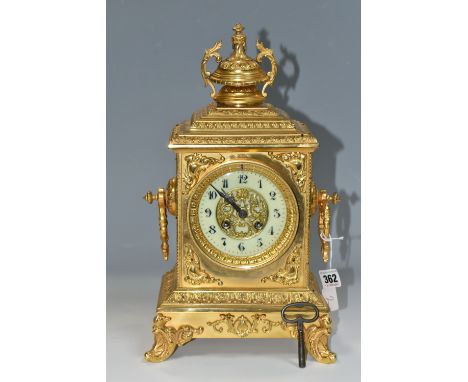 AN EARLY 20TH CENTURY GILT METAL MANTEL CLOCK, the rectangular case with twin handled finial on a stepped hood, the enamel di