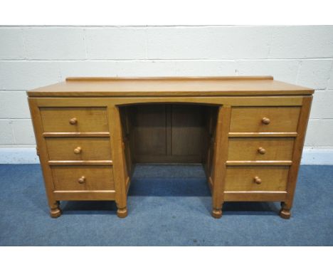 MOUSEMAN, A ROBERT THOMPSON OF KILBURN ENGLISH OAK PANELLED KNEE HOLE DESK, with an adzed top, and six drawers, on six octago