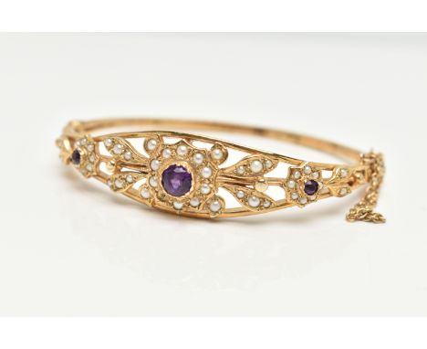 A 9CT GOLD AMETHYST AND SEED PEARL HINGED BANGLE, floral pattern bangle set with three circular cut amethysts and seed pearl 