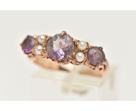 A YELLOW METAL AMETHYST AND SEED PEARL RING, designed with three circular cut amethysts, each claw set, interspaced with four