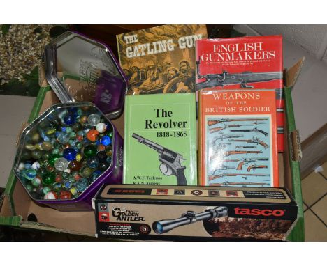 A BOX CONTAINING A TIN OF GLASS MARBLES, A BOXED TASCO GOLDEN ANTLER 3-9 X 40MM RIFLESCOPE AND THREE GUN RELATED BOOKS, compr