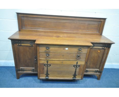 A WYLIE AND LOCHHEAD ARTS AND CRAFTS OAK BREAKFRONT SIDEBOARD, with a later raised back, panelled cupboard door flanking two 