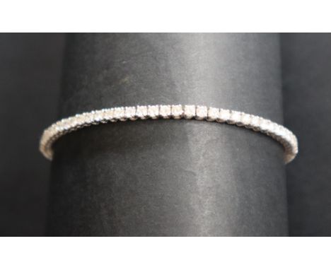 An 18ct white gold tennis bracelet set with eighty two round brilliant cut diamonds each approximately 0.05cts, 18.5cm long, 