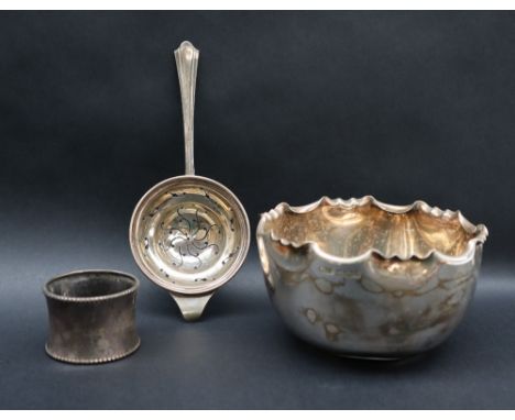 An Edward VII silver sugar basin, Sheffield, 1909, together with a tea strainer and napkin ring, approximately 165 grams