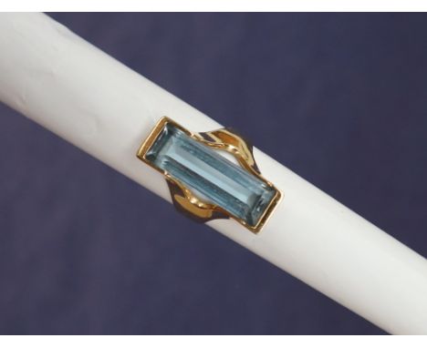 An 18ct yellow gold dress ring, set with a rectangular faceted blue spinel, 23 x 7mm, size O, marked 750 to the outside of th
