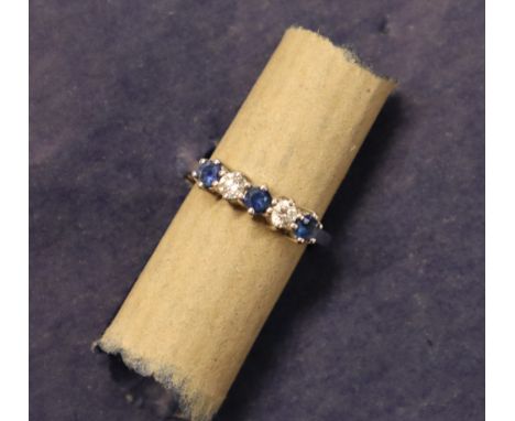 A sapphire and diamond line ring set with three circular faceted cur sapphires and two round brilliant cut diamonds to an 18c