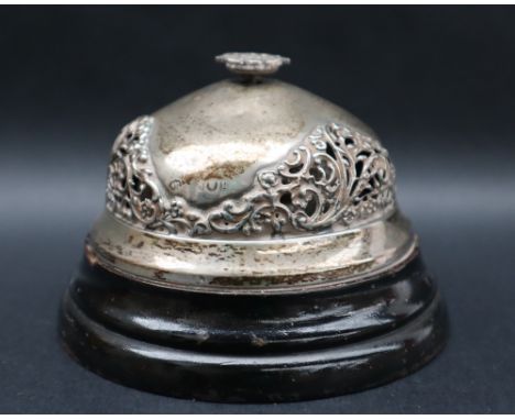 An Edward VII silver desk / counter bell, with a pierced button and bell on a wooden base, London, 1902 