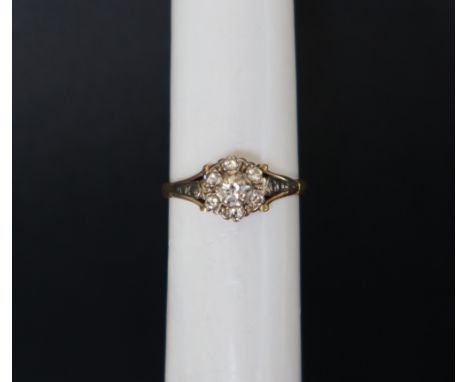 A diamond cluster ring set with round brilliant cut diamonds to a yellow metal setting and shank, size M 1/2, approximately 2