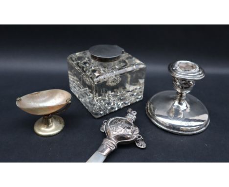 A George V silver candlestick, Birmingham, 1910 together with a silver topped inkwell, a silver and mother of pearl babies ra