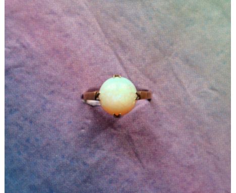 A 9ct yellow gold opal ring, set with a circular cabochon opal, 10mm diameter, size N, approximately 2.4 grams